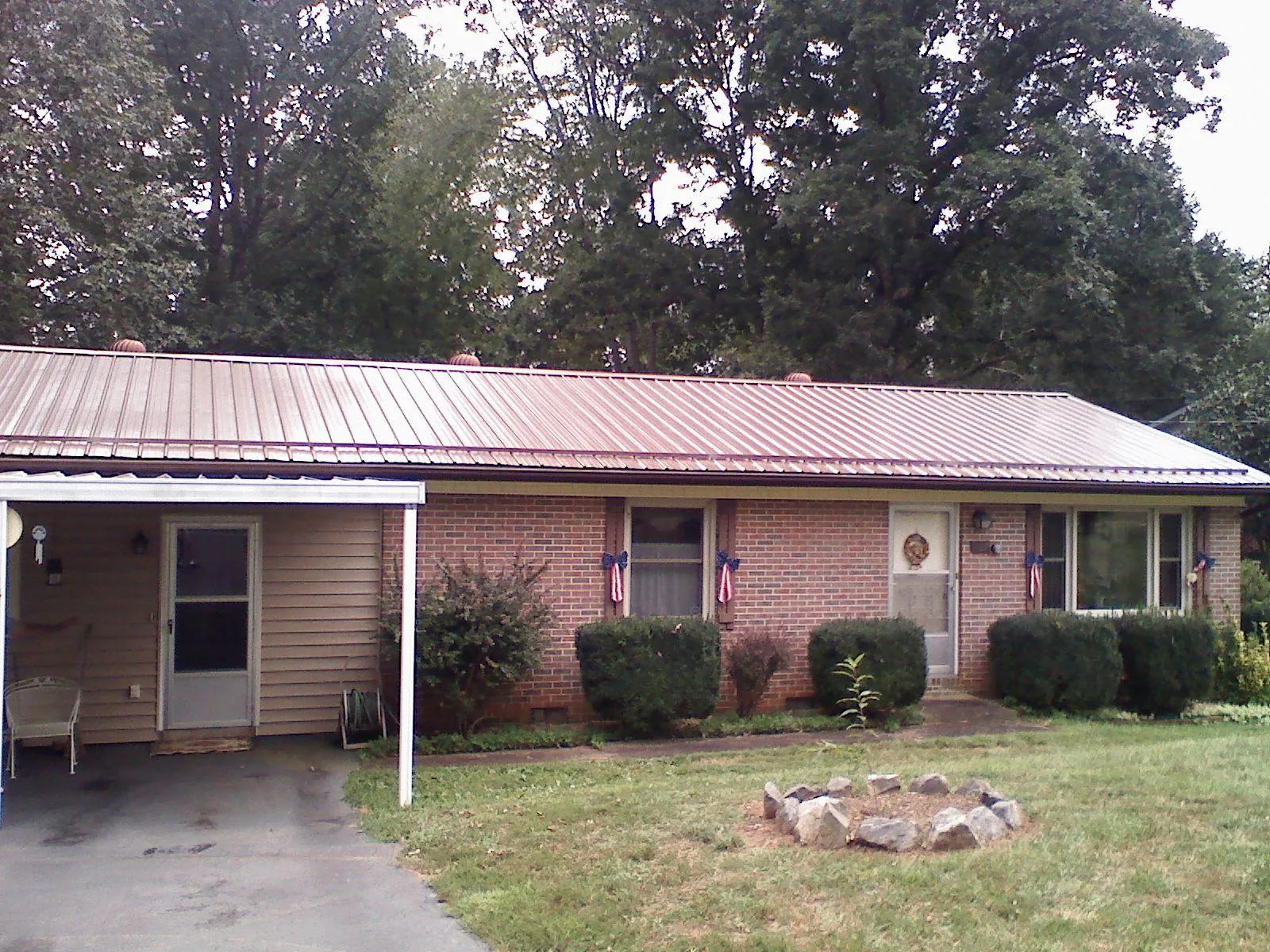 Bronze metal roof and carport on a brick ranch home — Roof Repair work by our crew in Neola